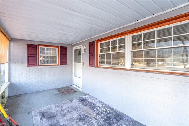 doorway to property with brick siding