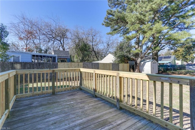 wooden terrace with an outbuilding, a fenced backyard, and a storage unit