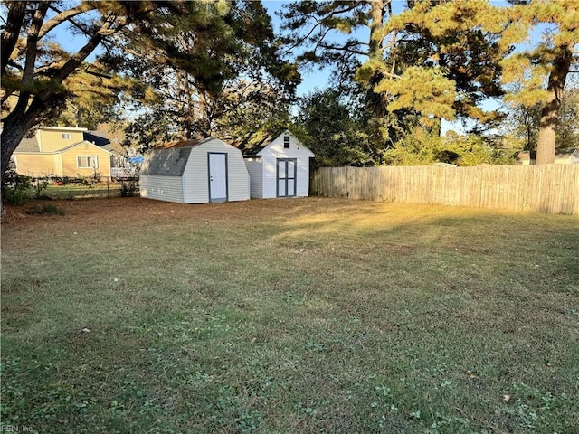 view of yard with a fenced backyard, a storage unit, and an outdoor structure