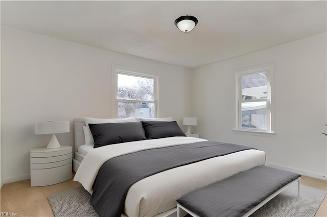 bedroom with light carpet and baseboards