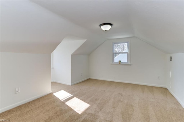 additional living space with light carpet, baseboards, and vaulted ceiling