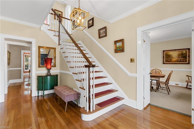 stairs with hardwood / wood-style floors, baseboards, and ornamental molding