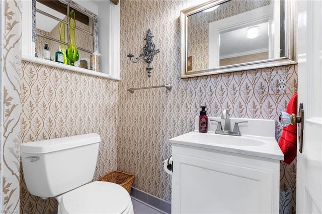 half bath featuring toilet, wallpapered walls, and vanity