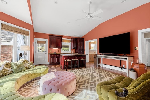 living area with a ceiling fan and vaulted ceiling