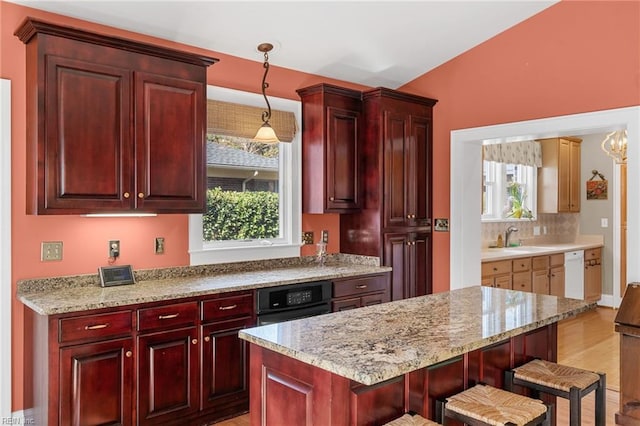 kitchen featuring black oven, dark brown cabinets, dishwasher, pendant lighting, and a sink