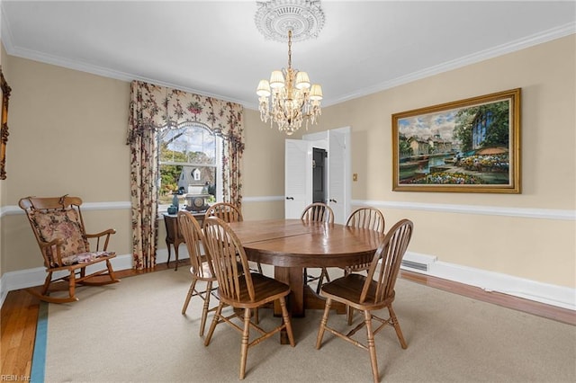 dining space with light wood finished floors, a chandelier, baseboards, and ornamental molding