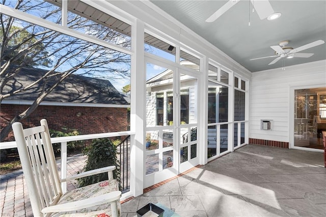 unfurnished sunroom featuring ceiling fan