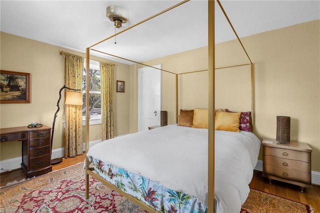 bedroom with baseboards and wood finished floors