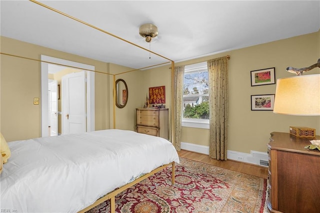 bedroom featuring baseboards and wood finished floors