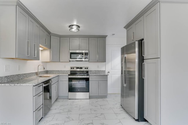 kitchen with light stone counters, marble finish floor, stainless steel appliances, gray cabinets, and a sink