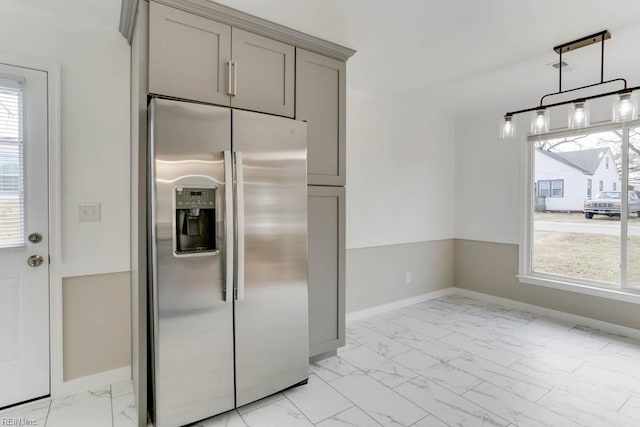 kitchen with gray cabinets, a wealth of natural light, marble finish floor, and stainless steel fridge