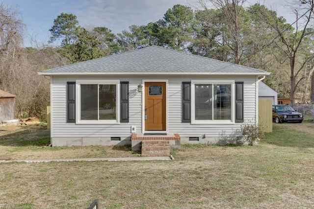 bungalow-style home with entry steps, a shingled roof, crawl space, and a front lawn