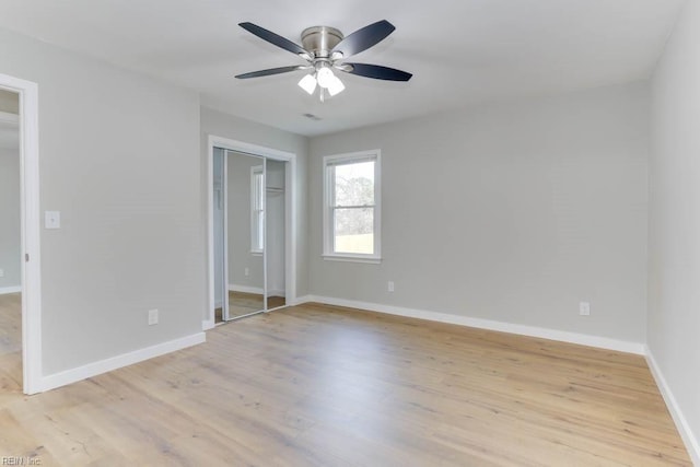 unfurnished bedroom featuring a ceiling fan, light wood-style flooring, and baseboards