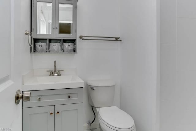 half bathroom with vanity and toilet