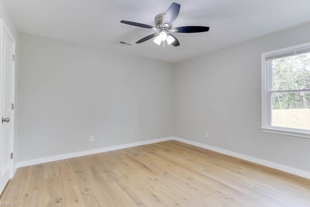 empty room with visible vents, ceiling fan, light wood-style flooring, and baseboards