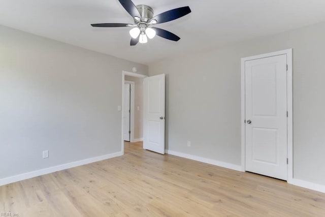 unfurnished bedroom with ceiling fan, light wood-type flooring, and baseboards