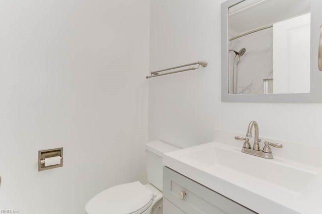 bathroom with a shower, vanity, and toilet