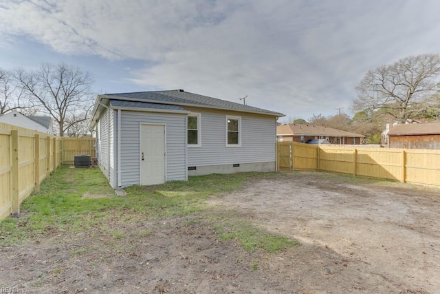 rear view of property featuring central AC, crawl space, and a fenced backyard