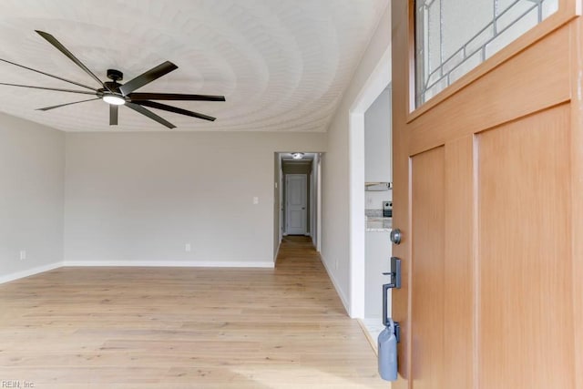 foyer entrance featuring a ceiling fan, baseboards, and light wood finished floors