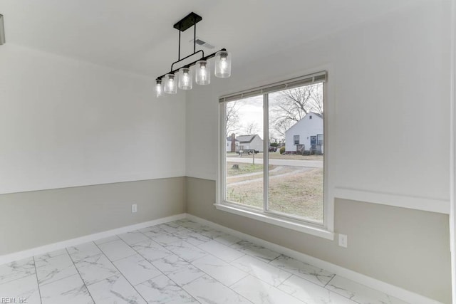 unfurnished dining area with marble finish floor and baseboards