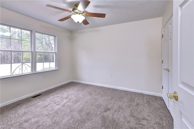 unfurnished room featuring visible vents, a textured ceiling, baseboards, and carpet floors