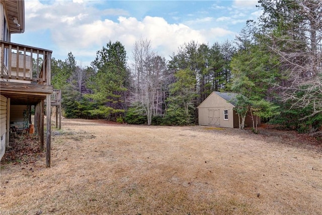 view of yard featuring an outbuilding, a storage unit, and a wooden deck