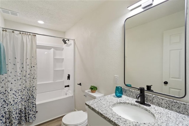 full bath featuring visible vents, toilet, shower / tub combo, a textured ceiling, and vanity