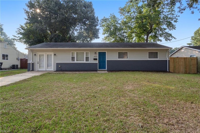 single story home featuring fence, a front lawn, and central AC