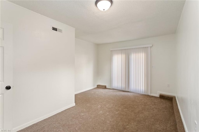 unfurnished room featuring a textured ceiling, carpet flooring, visible vents, and baseboards