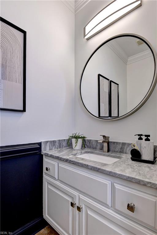 bathroom with vanity and ornamental molding