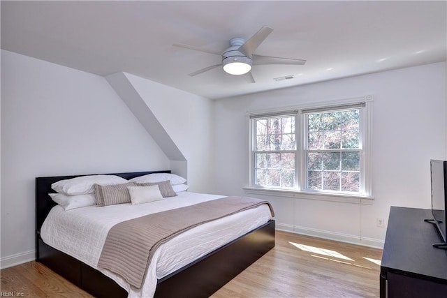 bedroom with visible vents, baseboards, and light wood finished floors