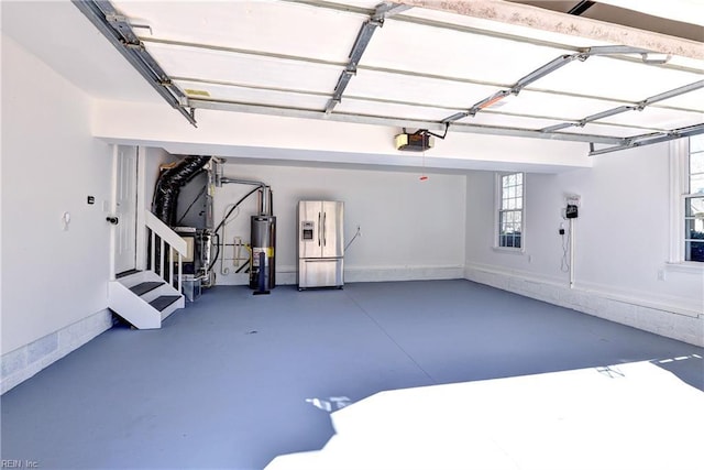 garage with gas water heater, baseboards, a garage door opener, and stainless steel refrigerator with ice dispenser