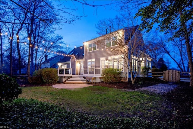 back of house with a lawn and a wooden deck