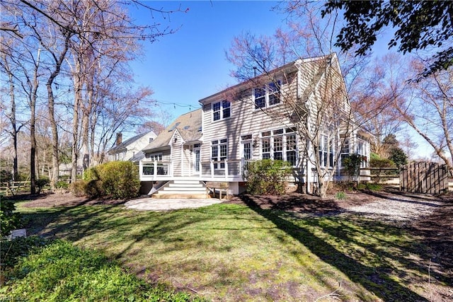 back of house featuring a yard and fence