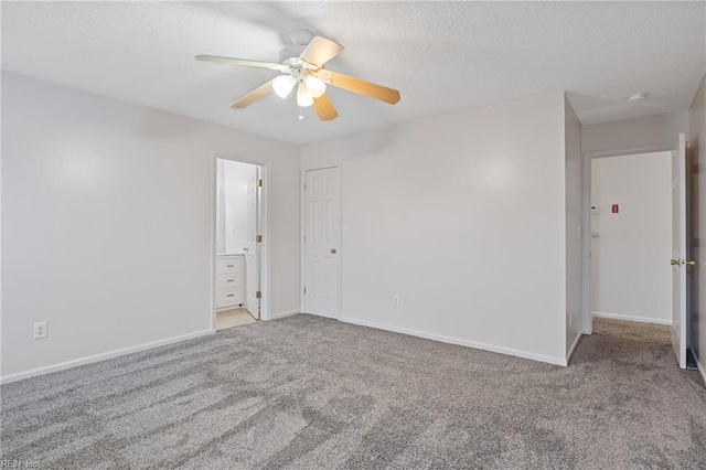 spare room with carpet, baseboards, ceiling fan, and a textured ceiling