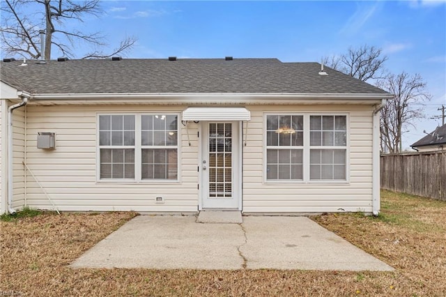 back of house with a yard, a shingled roof, a patio area, and fence