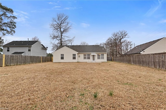 back of house with a yard and a fenced backyard