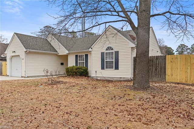 ranch-style home with a garage, fence, concrete driveway, and roof with shingles