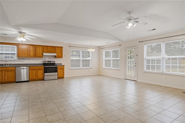 kitchen featuring under cabinet range hood, stainless steel appliances, a sink, visible vents, and brown cabinets