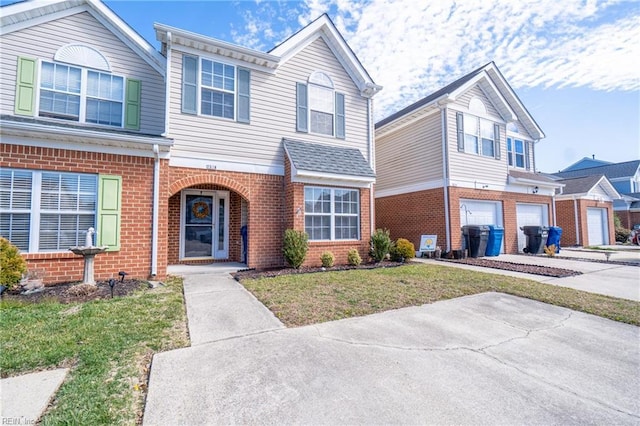 traditional home with brick siding, driveway, an attached garage, and a front lawn