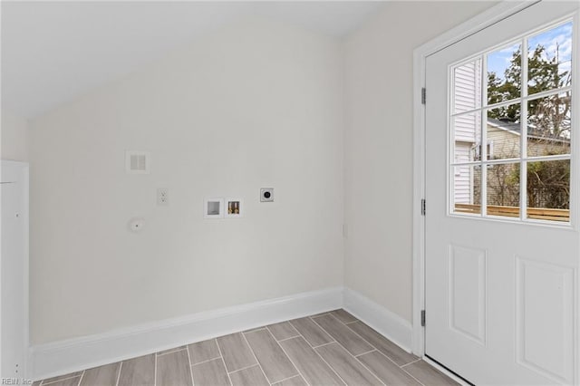 clothes washing area featuring a healthy amount of sunlight, laundry area, baseboards, and electric dryer hookup