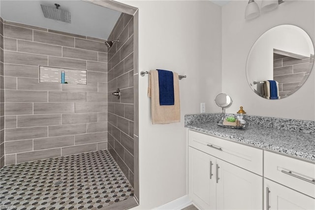 bathroom featuring tiled shower and vanity