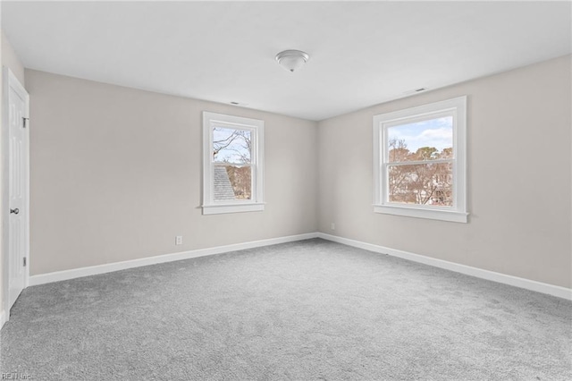 empty room featuring carpet and baseboards