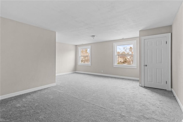 unfurnished room with carpet and baseboards