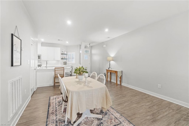 dining space featuring recessed lighting, light wood-type flooring, visible vents, and baseboards