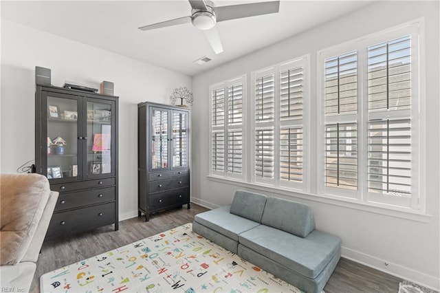 sitting room featuring ceiling fan, wood finished floors, and baseboards