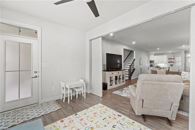 living area with recessed lighting, stairway, a ceiling fan, wood finished floors, and baseboards