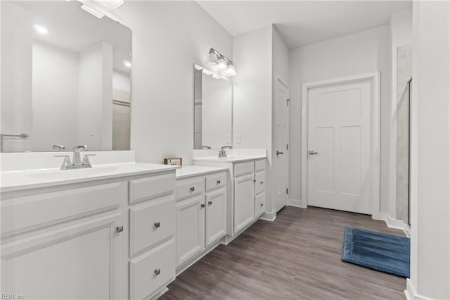 full bathroom with baseboards, a shower stall, vanity, and wood finished floors