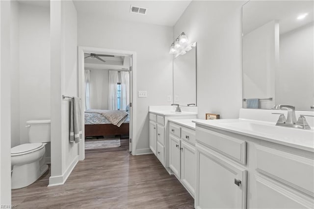 bathroom with toilet, ensuite bath, visible vents, and wood finished floors