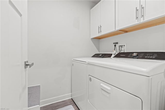 washroom featuring cabinet space, independent washer and dryer, baseboards, and wood finished floors